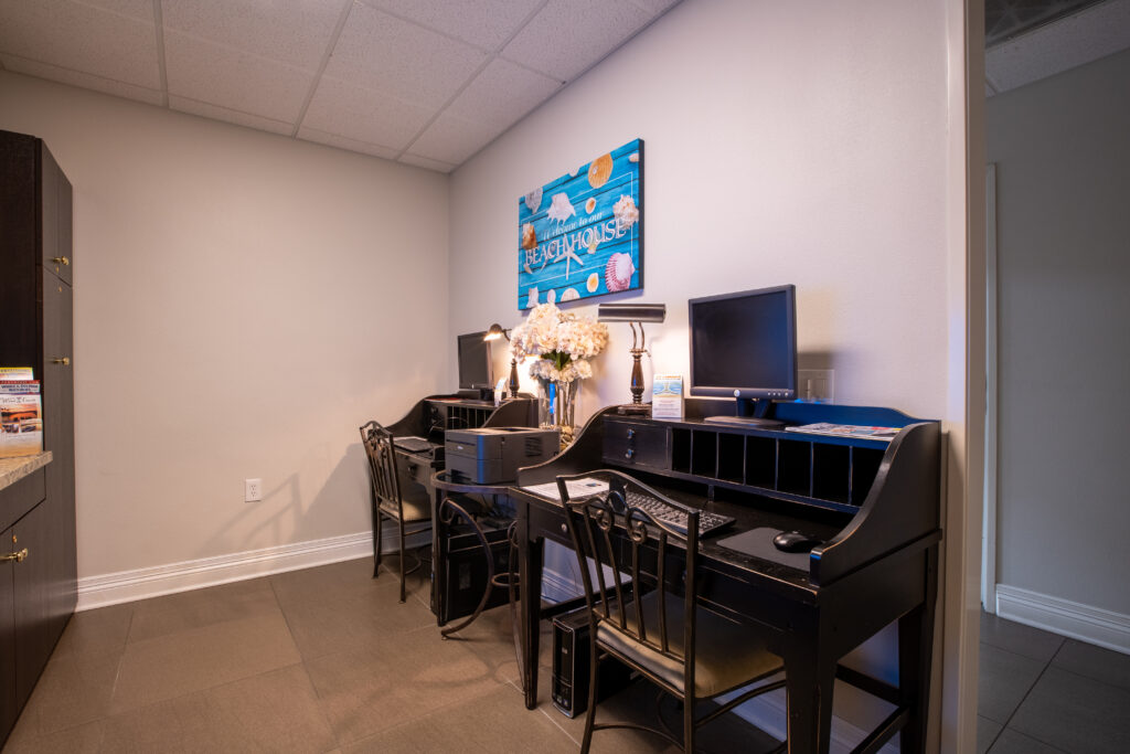 Room with a desk, chairs, television, and a painting on the wall