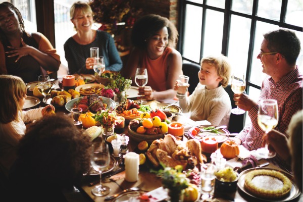family gathered around the dinner table eating thanksgiving meal