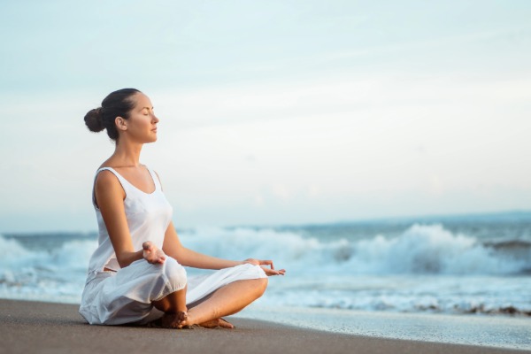 woman on the beach near san clemente praciticing yoga by the ocean